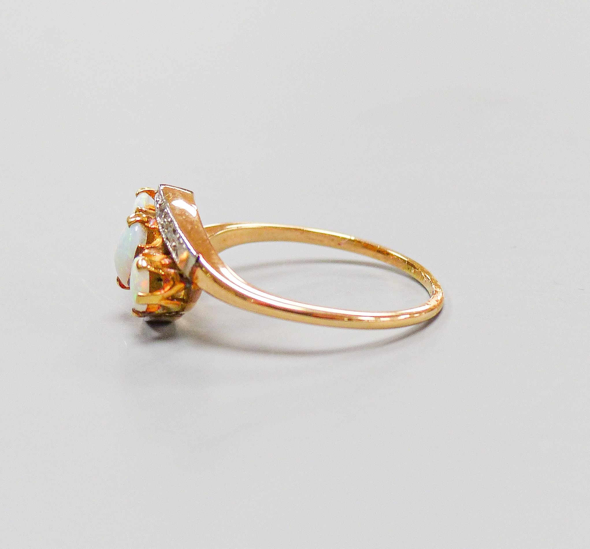 An 18ct and plat, three stone white opal and diamond chip set crossover ring, size S, gross weight 4.1 grams.